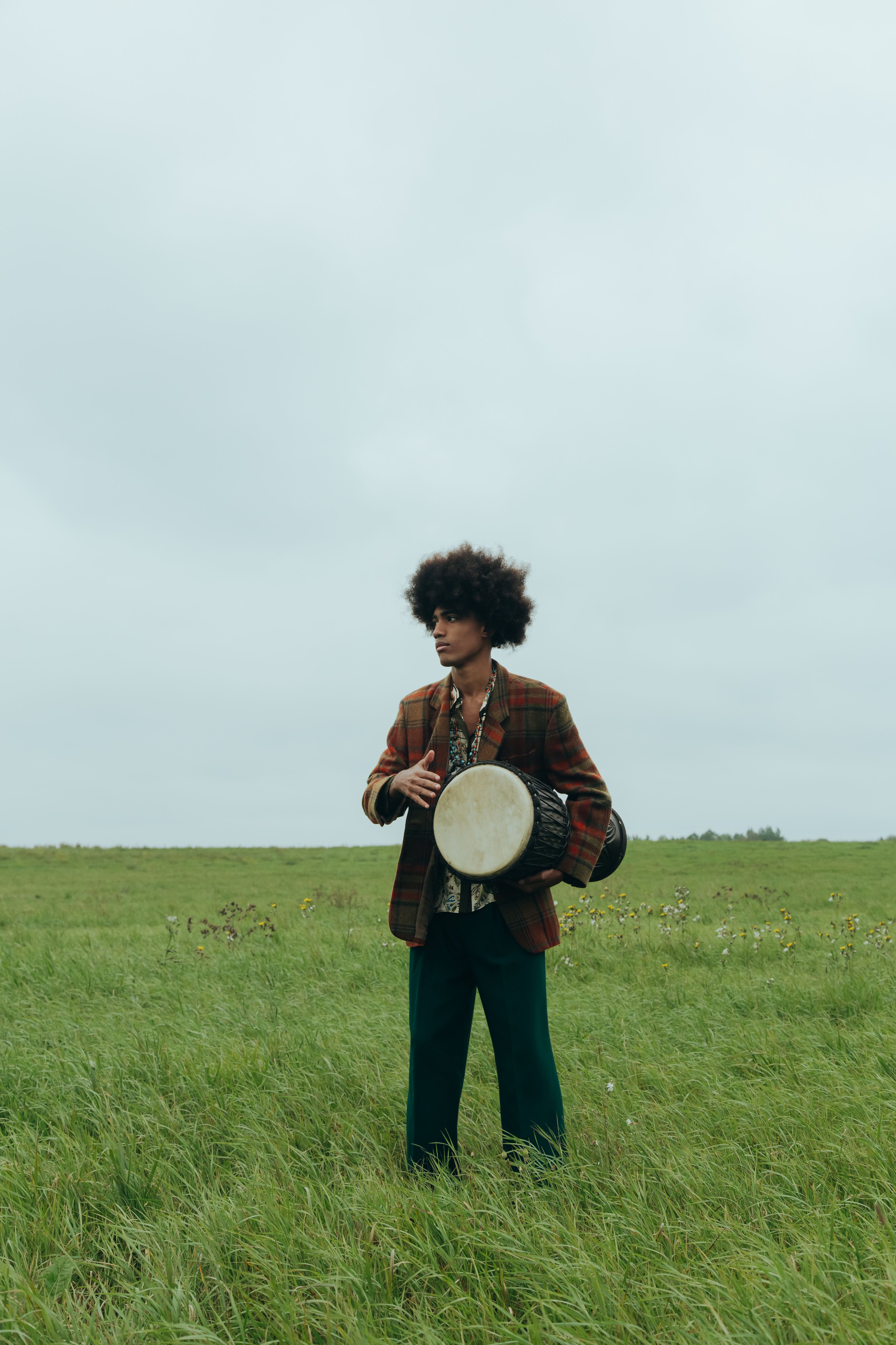A man playing a djembe in a field