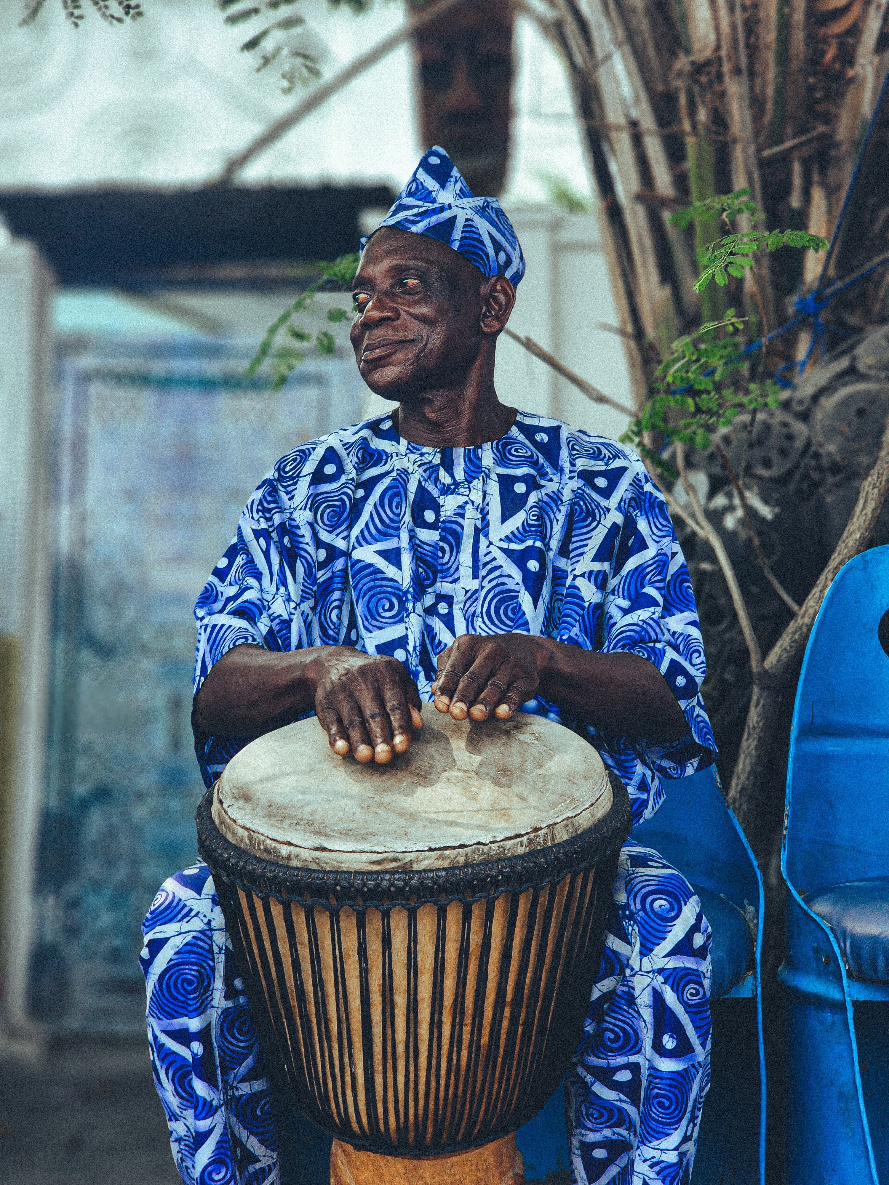 An elder playing a traditional drum